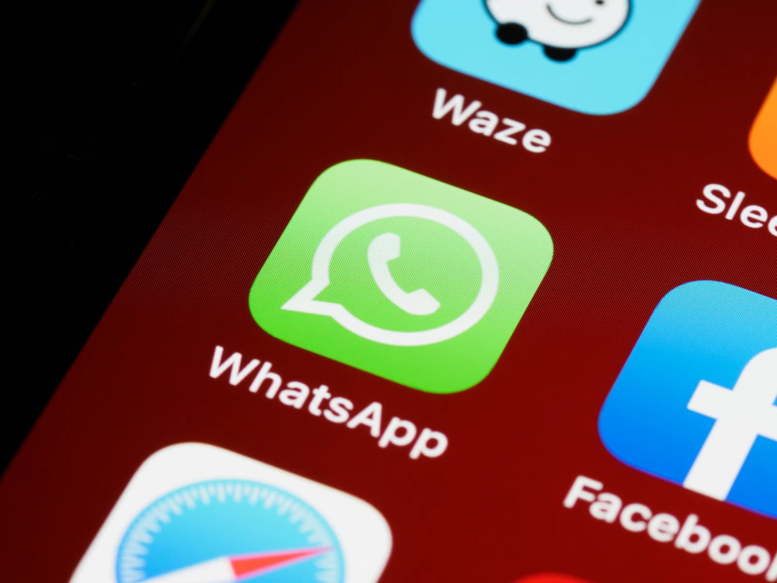 A phone home screen with the WhatsApp app icon