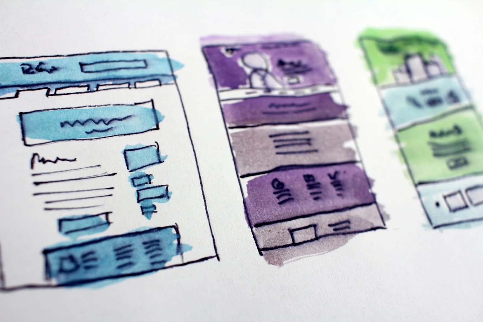 Watercolour sketches of website page layouts laid side by side